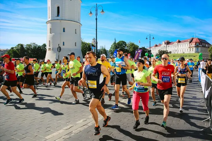 Large group of runners taking part in a marathon on a sunny day